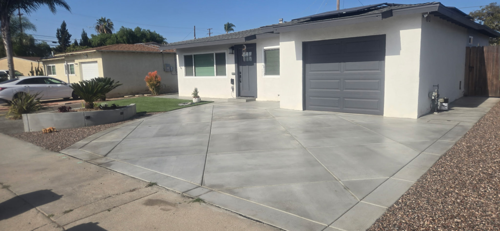 Decorative concrete driveway with diamond control joints and a curved planter wall